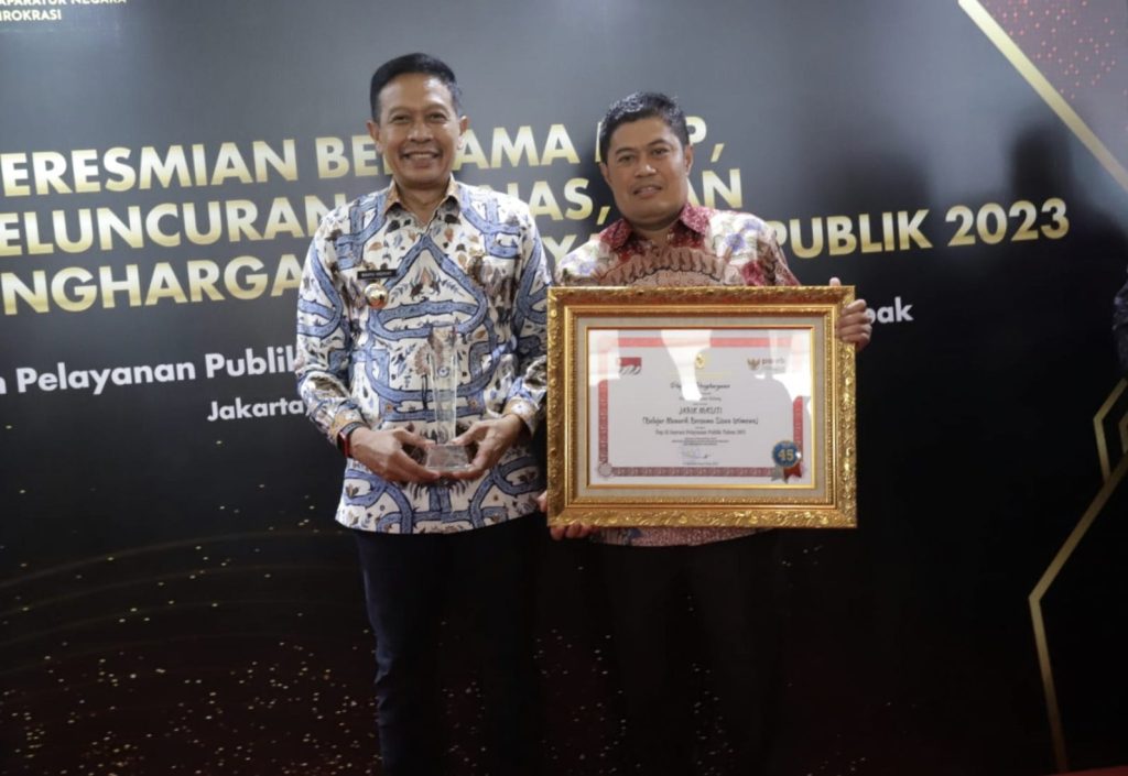 Pj. Wali Kota dan Kepala Dinas Pendidikan Kota Malang menerima penghargaan Pelayanan Publik 2023. (Foto: Ist/Politikamalang)
